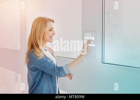 Positive programmer entering password while using her modern device Stock Photo