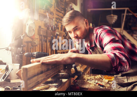 carpenter working with wood plank at workshop Stock Photo