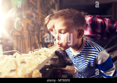 father and little son with wood plank at workshop Stock Photo