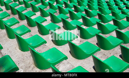 Many green plastic seats in rows in an empty stadium. Stock Photo