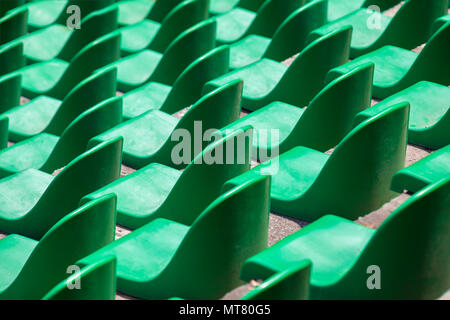 Green plastic seats in rows in an empty stadium. Stock Photo