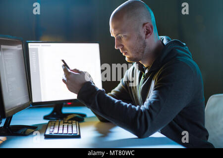 hacker with smartphone and computers in dark room Stock Photo - Alamy