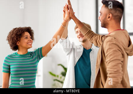 happy creative team making high five at office Stock Photo
