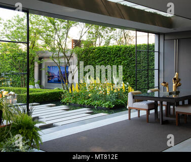 A view to the garden and a bed of Lupins from the dining area in LG Eco-City Garden at the RHS Chelsea Flower Show 2018. Stock Photo