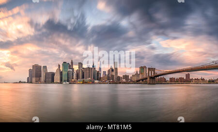 New York, New York, USA skyline of Manhattan on the East River with Brooklyn Bridge a dusk.