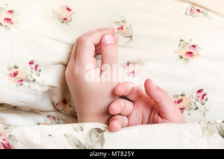 Children hands, peeping out from under blanket Stock Photo