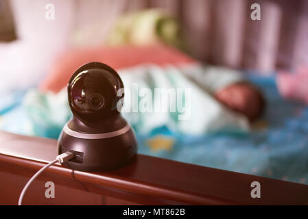 Watching sleeping newborn baby with home camera. One dome camera Stock Photo