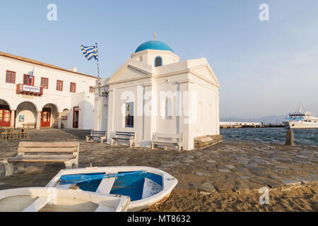 MYKONOS, GREECE - MAY 2018: Two boats lying on the sand in front of saint Nicolas Church in Mykonos old town, Greece. Wide angle lens shot at sunrise. Stock Photo