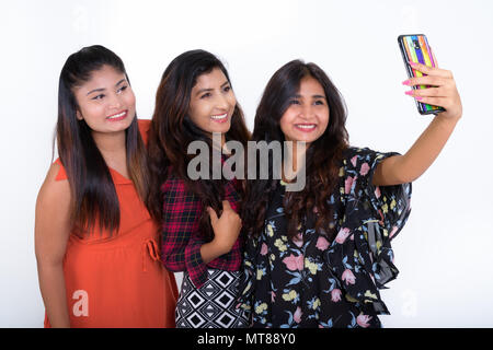 Three happy young Persian woman friends smiling while taking sel Stock Photo