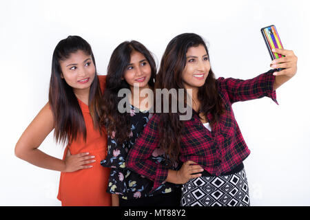 Studio shot of three happy young Persian woman friends smiling a Stock Photo