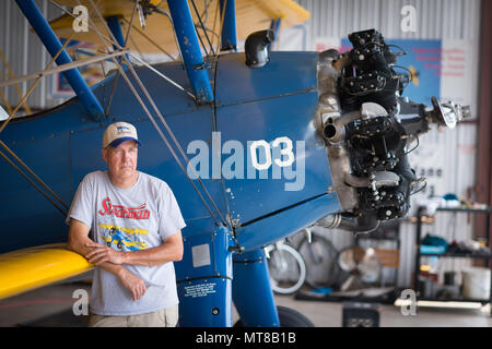 First Sgt. David Brown, Air Force Reserve, leans on his PT-17 Stearman bi-plane in his hanger at Warrenton-Fauquier Airport in Warrenton, Va., Jul. 20, 2017. Brown has been flying since he was a teenager and began working at the Flying Circus Aerodrome in Bealeton, Va. (U.S. Air Force photo by J.M. Eddins Jr.) Stock Photo