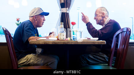 Al Tucker Jr.'s talks with First Sgt. David Brown, Air Force Reserve, over dinner at a restaurant near Brown's hanger at Warrenton-Fauquier Airport in Warrenton, Va., Jul. 28, 2017. Tucker, now 96, regularly makes the trip from Lexington, Va., to fly Brown's PT-17 Stearman biplane, the same model in which Tucker trained in 1942 before going on to fly P-38 fighter aircraft over Europe with the U.S. Army Air Corps during WWII with his friend, then Lt. Robin Olds. (U.S. Air Force photo by J.M. Eddins Jr.) Stock Photo