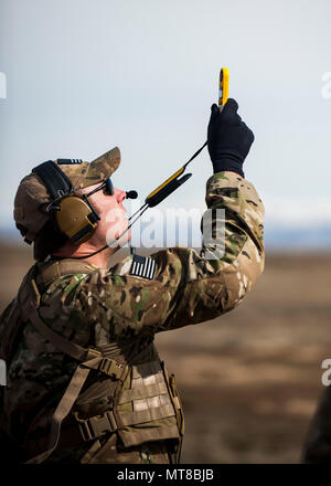 Tech. Sgt. Ben Domain, a Survival, Evasion, Resistance, and Escape (SERE) specialists with the 308th Rescue Squadron, checks winds speed on a landing zone for pararescuemen parachuting out of a HC-130J Combat King II, March 2, 2017, at the Orchard Combat Training Center in Idaho, during pre-deployment training for the 305th Rescue Squadron. The 305th RQS, located at Davis-Monthan Air Force Base, Ariz., is conducting training at the Idaho Air National Guard’s Orchard Combat Training Center, a 143,000-acre live-fire range located south of Boise, Idaho, to hone all of their search and rescue proc Stock Photo