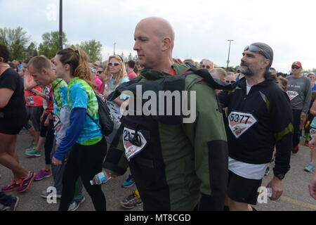 U.S. Air Force Senior Master Sgt. Bill Kennedy, a 119th Wing Explosive Ordnance Disposal (EOD) technician, North Dakota Air National Guard, walks toward the start of the 5K Hero Run event wearing an 88 pound bomb protection suit as he prepares to run wearing the suit at the Fargo Marathon, Fargo, N.D., May 19, 2017. The Fargo Marathon weekend running events have a hero theme because Armed Forces Day occurs during the events, Saturday, May 20. (U.S. Air National Guard Photo by Senior Master Sgt. David H. Lipp/Released) Stock Photo