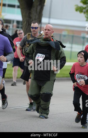 U.S. Air Force Senior Master Sgt. Bill Kennedy, a 119th Wing Explosive Ordnance Disposal (EOD) technician, North Dakota Air National Guard, runs the 5K Hero Run event wearing an 88 pound bomb protection suit at the Fargo Marathon, Fargo, N.D., May 19, 2017. The Fargo Marathon weekend running events have a hero theme because Armed Forces Day occurs during the events, Saturday, May 20. (U.S. Air National Guard Photo by Senior Master Sgt. David H. Lipp/Released) Stock Photo