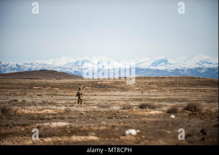 Tech. Sgt. Ben Domain, a Survival, Evasion, Resistance, and Escape (SERE) specialists with the 308th Rescue Squadron, checks wind direction on a landing zone for pararescuemen parachuting out of a HC-130J Combat King II, March 2, 2017, at the Orchard Combat Training Center in Idaho, during pre-deployment training for the 305th Rescue Squadron. The 305th RQS, located at Davis-Monthan Air Force Base, Ariz., is conducting training at the Idaho Air National Guard’s Orchard Combat Training Center, a 143,000-acre live-fire range located south of Boise, Idaho, to hone all of their search and rescue p Stock Photo