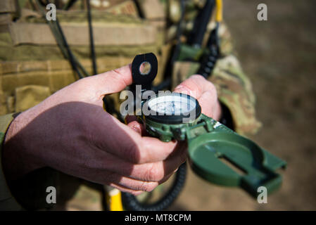 Tech. Sgt. Ben Domain, a Survival, Evasion, Resistance, and Escape (SERE) specialists with the 308th Rescue Squadron, checks a compass before marking a landing zone for pararescuemen parachuting out of a HC-130J Combat King II, March 2, 2017, at the Orchard Combat Training Center in Idaho, during pre-deployment training for the 305th Rescue Squadron. The 305th RQS, located at Davis-Monthan Air Force Base, Ariz., is conducting training at the Idaho Air National Guard’s Orchard Combat Training Center, a 143,000-acre live-fire range located south of Boise, Idaho, to hone all of their search and r Stock Photo