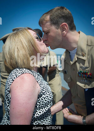 170602-N-GR120-450 NORFOLK (June 2, 2017) Senior Chief Aviation Electronics Technician Robert Mathes kisses his wife during a senior chief petty officer frocking ceremony held aboard the aircraft carrier USS George Washington (CVN 73). George Washington is homeported in Norfolk preparing to move to Newport News, Virginia for the ship’s refueling complex overhaul (RCOH) maintenance. (U.S. Navy photo by Mass Communication Specialist 3rd Class Anna Van Nuys) Stock Photo