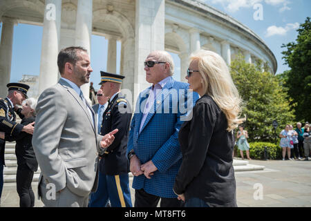 Micheal Migliara (left), director of events and ceremonies, Arlington National Cemetery; Terry Bradshaw (center), representative of United Service Organization (USO) Metro; and his wife, Tammy Bradshaw (right); speak at the west steps of the Memorial Amphitheater at Arlington National Cemetery, Arlington, Virginia, May 11, 2018. Bradshaw participated in an Army Special Honors Wreath-Laying at the Tomb of the Unknown Soldier during his visit. (U.S. Army photo by Elizabeth Fraser / Arlington National Cemetery/ released) Stock Photo