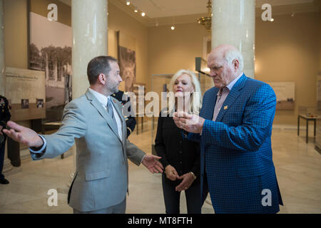 Micheal Migliara (left), director of events and ceremonies, Arlington National Cemetery; presents an Arlington National Cemetery coin to Terry Bradshaw (right), representative of United Service Organization (USO) Metro; and his wife, Tammy Bradshaw (center) in the Memorial Amphitheater Display Room at Arlington National Cemetery, Arlington, Virginia, May 11, 2018. Bradshaw participated in an Army Special Honors Wreath-Laying at the Tomb of the Unknown Soldier during his visit. (U.S. Army photo by Elizabeth Fraser / Arlington National Cemetery/ released) Stock Photo