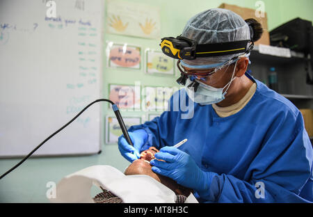 U.S. Air Force Master Sgt. Emeriles Curry, 346th Expeditionary Medical Operations Squadron dental hygienist, provides dental care to a local man May 11, 2018 in the Coclé Province of Panama. So far, in 2-weeks’ worth of Medical Readiness Training Exercises the teams, working in conjunction with the Panamanian Ministry of Health, have seen nearly 4,700 patients and 502 animals. The medical team is participating in Exercise New Horizons 2018, which is a joint training exercise focused on civil engineer, medical, and support service personnel’s ability to prepare, deploy, operate, and redeploy ou Stock Photo