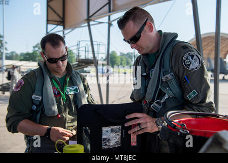 Capt. Bowman (right), 335th Fighter Squadron pilot, and 1st Lt. Kaiser, 335th FS weapon systems officer, check over the maintenance log of an F-15E Strike Eagle during exercise Razor Talon, May 11, 2018, at Seymour Johnson Air Force Base, North Carolina. Razor Talon is a monthly, large-force training exercise for joint East Coast tactical and support aviation units. (U.S. Air Force photo by Airman 1st Class Shawna L. Keyes) Stock Photo