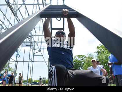 Airman 1st Class William Gordon, 11th Comptroller Squadron financial operations technician, climbs down the “Devil’s Ladder” on the Alpha Warrior Battle Rig during the 2018 Alpha Warrior Battle Rig Tour on Joint Base Andrews, Md., May 12, 2018. The program is an Air Force-wide fitness initiative to incorporate a functional fitness approach for Airmen to tackle the four pillars of Comprehensive Airmen Fitness: physical, mental, social and spiritual to achieve readiness and resiliency at home and while deployed.  (U.S. Air Force photo by Airman Michael S. Murphy) Stock Photo