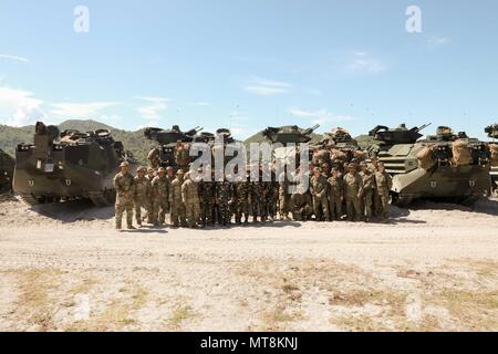 Philippine Army soldiers from the 72nd Division Reconnaissance Company, 7th Infantry Division, along with U.S. service members from 1st Battalion, 21st Infantry Regiment, 2nd Infantry Brigade Combat Team, 25th Infantry Division and 3rd Medical Battalion, 3rd Marine Logistics Group, gather for a photo in front of a Marine Corps AAV7A1 assault amphibious vehicle on Colonel Ernesto Ravina Air Base, Tarlac, Philippines, May 13, 2018. The service members exchanged their tactics, techniques and procedures for providing tactical combat casualty care with their counterparts as part of Exercise Balikat Stock Photo
