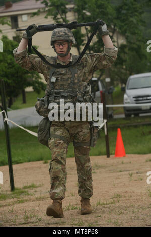 U.S. Army 2nd Lt. Brian Trabun, a native of Seattle, WA, assigned to the 35th Air Defense Artillery Brigade, performs the performs lunges while hold his M4 carbine above his head during the Eighth Army Best Warrior Competition at Camp Casey, Republic of Korea, May 17, 2018. The Eighth Army Best Warrior Competition is being held to recognize and select the most qualified junior enlisted and non-commissioned officer to represent Eighth Army at the U.S. Army Pacific Best Warrior Competition at Schofield Barracks, HI. The competition will also recognize the top performing officer, warrant officer  Stock Photo