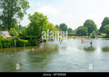 Fordingbridge, Hampshire, UK, 28th May 2018, Weather: Rriverside park is busy with people out enjoying the glorious hot bank holiday weather by the cool water of the river Avon as it flows through the New Forest town. Stock Photo