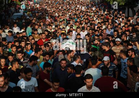 Gaza. 28th May, 2018. Mourners carry the body of Palestinian Mohamed al-Radee'a, 25, who was killed in the fresh Israeli army shelling near northern Gaza Strip town of Beit Lahia, on May 28, 2018. Mohamed al-Radee'a was killed and another injured on Monday in an Israeli tank shelling on military facilities that belong to Islamic Hamas movement in northern Gaza Strip, medics said. Credit: Stringer/Xinhua/Alamy Live News Stock Photo