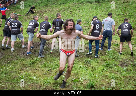 Gloucester, UK. 28th May 2018. Annual Cheese Roll on Coopers Hill. Dating back to 1800s, the annual Cheese-Rolling and Wake race involves fearless competitors chasing a 9lb (4.1KG) round of Double Gloucester cheese 200 meters down the 1:2 gradient hill. The cheese is allowed a one-second head start and can reach speeds up to 70mph. There are usually a number of injuries each year. Credit: Guy Corbishley/Alamy Live News Stock Photo