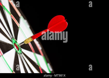 Close up shot red darts arrows in the target center on black background. Business target or goal success and winner concept. Stock Photo