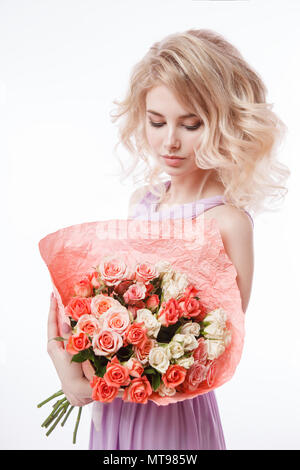 Portrait of beautiful curly blondy woman with perfect make-up. Holding bouquet Stock Photo