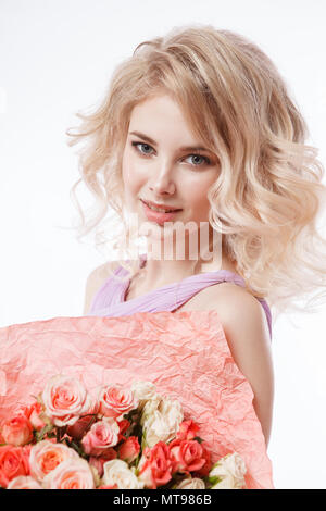 Portrait of beautiful curly blondy woman with perfect make-up. Holding bouquet Stock Photo