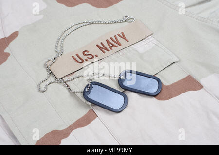 KIEV, UKRAINE - May 9, 2015. US NAVY branch tape with dog tags on desert camouflage uniform background Stock Photo