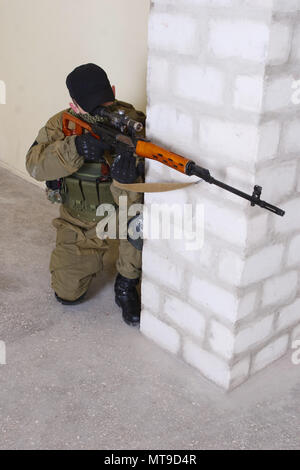 guerillas sniper with sniper rifle inside the building Stock Photo