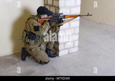 guerillas sniper with sniper rifle inside the building Stock Photo