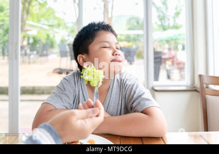 obese fat boy with expression of disgust against vegetables, Refusing food concept Stock Photo
