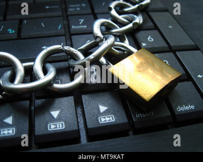 Chain with lock on computer keyboard. It means block chain technology using or laptop banned or internet banned. Symbol of computer addiction, games, Stock Photo
