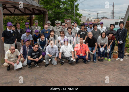 Volunteers from Yokota Air Base, Japan and the city of Fussa, Japan pose for a photo following the closing ceremony on day one of the Fussa Beautification Project in Fussa, May 17, 2018. The event gave members of Team Yokota a chance to team up with the local community to plant flowers and make the area a more beautiful place. (U.S. Air Force photo by Airman 1st Class Matthew Gilmore) Stock Photo