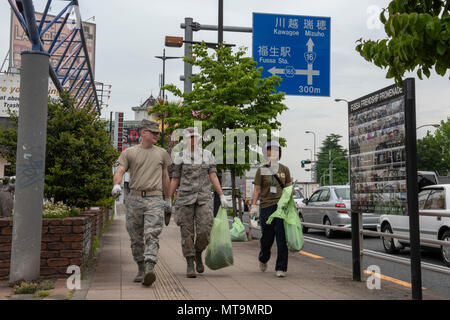 Volunteers from Yokota Air Base, Japan and the city of Fussa carry bags of weeds to be disposed of immediately following the Fussa Beautification Project in Fussa, May 17, 2018. The event gave members of Team Yokota a chance to team up with the local community to plant flowers and make the area a more beautiful place. (U.S. Air Force photo by Airman 1st Class Matthew Gilmore) Stock Photo