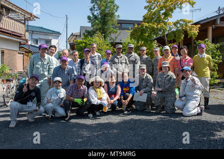 Volunteers from Yokota Air Base, Japan and the city of Fussa, Japan pose for a photo following the closing ceremony on day one of the Fussa Beautification Project in Fussa, May 14, 2018. The event gave members of Team Yokota a chance to team up with the local community to plant flowers and make the area a more beautiful place. (U.S. Air Force photo by Airman 1st Class Matthew Gilmore) Stock Photo