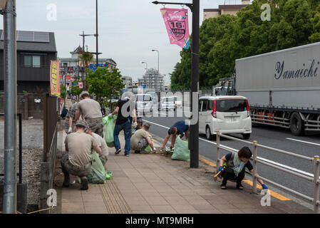 Volunteers from Yokota Air Base, Japan and the city of Fussa complete the finishing touches of cleaning up after the Fussa Beautification Project in Fussa, May 17, 2018. The event gave members of Team Yokota a chance to team up with the local community to plant flowers and make the area a more beautiful place. (U.S. Air Force photo by Airman 1st Class Matthew Gilmore) Stock Photo