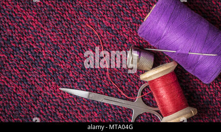spools of colored threads against the background of knitted fabric Stock Photo