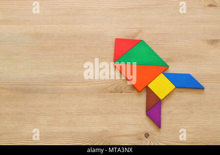 rocket made from tangram puzzle on blue pastel wooden background Stock Photo