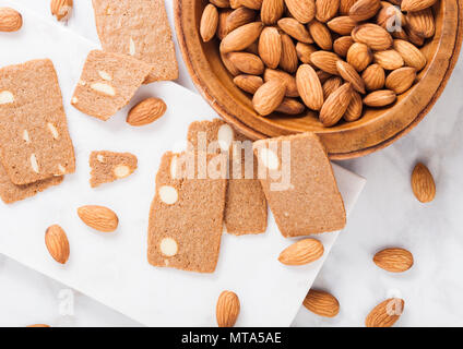 Homemade almond biscuit cookies with raw almonds and butter on white marble  background Stock Photo