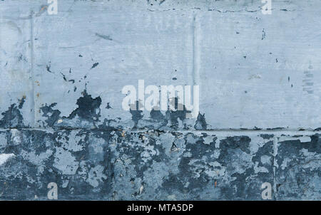 Blue concrete wall grunge texture with cracks. Cracks, scrapes, peeling old paint and plaster on background of old cement wall. An old cement stone wall as vintage cracked. Stock Photo