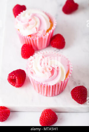 Cupcake muffin with raspberry cream dessert on marble background with freshraspberry Stock Photo