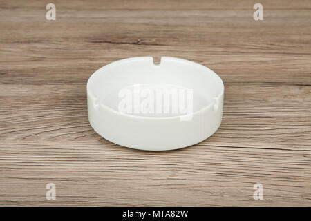 White ceramic ashtray on a wooden background Stock Photo